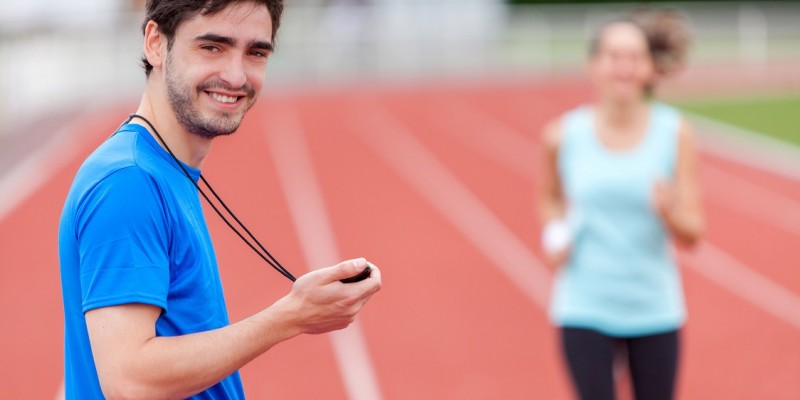 Sport coach training a young attractive woman on a stadium