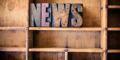 The word NEWS written in vintage wooden letterpress type in a wooden type drawer.