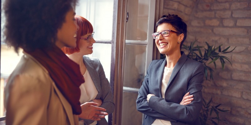 Group of females at work talking together in office