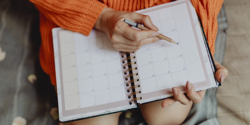 Woman writing on her daily planner